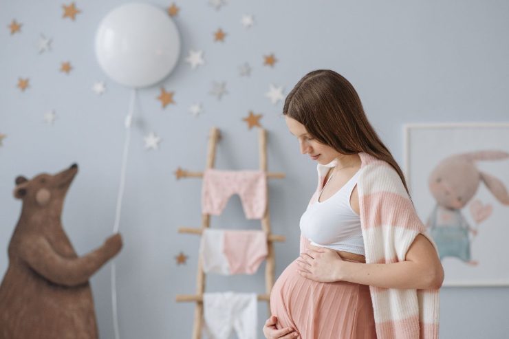 donna incinta dentro cameretta neonato